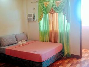 BanbanRedDoorz @ 4ks Pension House Bogo City Cebu的彩虹窗帘的房间的一张床位