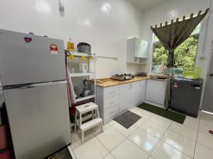 麻坡GS24 Muar的厨房配有白色橱柜和冰箱。