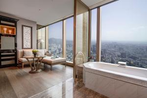 南京南京丽思卡尔顿酒店的一间带浴缸的浴室和一间享有美景的客厅