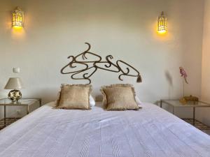 法鲁Casa Pedra Rosa - VINHAS de NEXE的一间卧室配有一张带两盏灯的大型白色床。