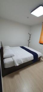 统营市High-Quality House Ocean view的一间卧室配有一张带白色床单的大床