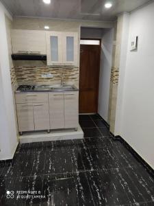 巴亚索拉诺Apartamentos Olaya!的厨房配有白色橱柜和黑色地板