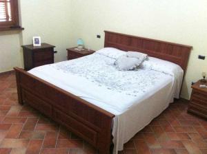 ValtopinaOspitaci Appartamenti di campagna Le Rancole的一间卧室配有一张大床和木制床头板