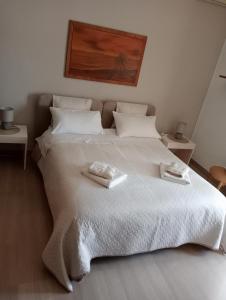 莱切A casa di Gio的卧室配有一张白色大床和两条毛巾