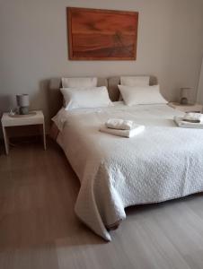 莱切A casa di Gio的卧室配有一张带两张桌子的大型白色床