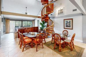 圣乔治岛Knot Too Shabby的一间带桌椅的用餐室和螺旋楼梯