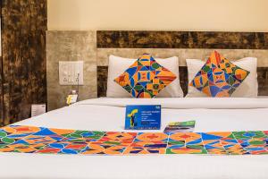 孟买FabHotel Consulate CST的床上配有色彩缤纷的被子和枕头