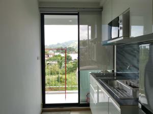 普吉镇4 Floor - Centrio Condominium in Phuket town的厨房设有滑动玻璃门,通往阳台
