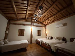 北竿芹壁小玖窩民宿的客房设有三张床和木制天花板。