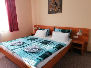 奎德林堡加尼祖金戒指酒店的一张带蓝色毯子的床和两张毛巾
