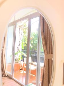 胡志明市Chez Lotus Rose的客厅里的拱形镜子,带有开放式窗户
