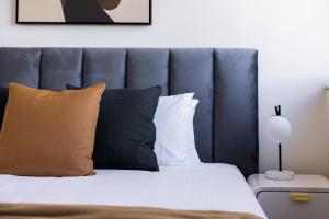 悉尼The Horizon Apartments by Urban Rest的一间卧室配有一张带蓝色床头板和枕头的床。