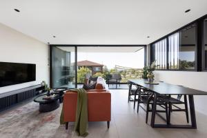悉尼The Horizon Apartments by Urban Rest的开放式客厅配有桌子和沙发