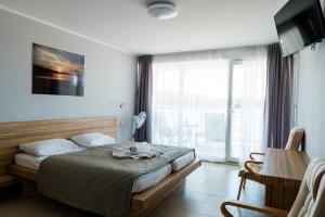 DługiePensjonat Długie Nowicki Rooms & Apartments的一间卧室设有一张床和一个大窗户