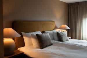 舍夫德Billingehus的一间卧室配有一张带枕头的床和两盏灯。