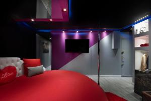 图卢兹Secret Night II的一间设有红色床和电视的房间