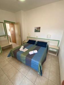 阿祖罗港杜托利酒店的一间卧室配有一张大床和两条毛巾
