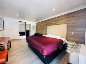 惠蒂尔Casa Blanca Inn & Suites Whittier的一间卧室配有红色的床和一张书桌