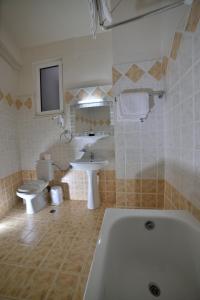 米斯特拉斯拜占庭酒店的带浴缸、卫生间和盥洗盆的浴室