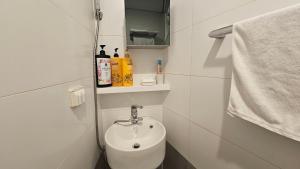 首尔金氏旅馆的白色的浴室设有水槽和毛巾