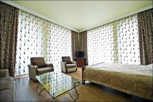 巴统艾菲尔酒店的一间卧室配有一张床、一张沙发和椅子