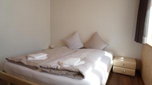 因内特基尔兴友安非沃格酒店的一张带白色床单和枕头的床