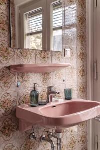 韦尔特湖畔克伦彭多夫Apartments Obir am Wörthersee的浴室设有粉红色的盥洗盆和镜子