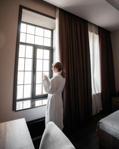 巴库OLF Hotel的站在酒店房间,望向窗外的女人