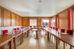 索恩河畔自由城Hôtel Newport的大房间设有木桌和红色椅子