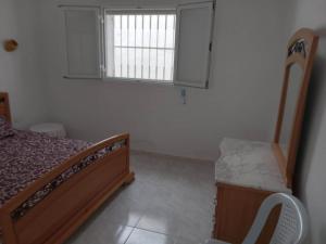 古莱比耶Confortable Maisonnette prés de la plage à Dar el Alouch的一间小卧室,配有床和窗户