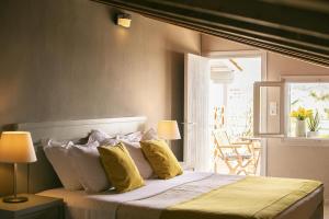 梅加利阿莫斯Nimfi Hotel, Skiathos的一间卧室配有一张带黄色枕头的大床