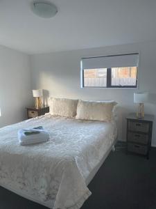 霍基蒂卡安柏里小屋的卧室配有白色床、两盏灯和一扇窗户。