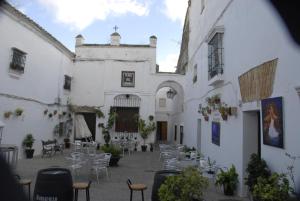 阿尔科斯-德拉弗龙特拉Casa Rural Las Cadenas del Cananeo的白色建筑的庭院,配有桌椅