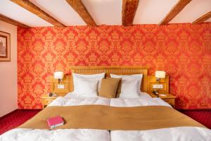 施特拉尔松德施特拉尔松斯科勒霍夫浪漫酒店的一间卧室设有一张床和红色的墙壁