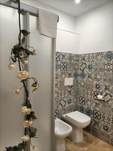 维罗纳Al Filarmonico的浴室设有卫生间,并种植了鲜花。