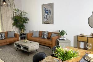 阿布扎比Yas Island Oasis Getaway 1BR Amazon的客厅配有棕色的沙发和桌子