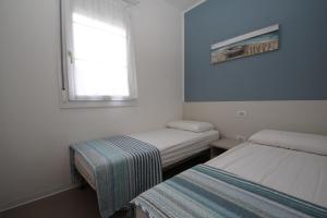 罗索利纳马雷Residence Verdena appartamento 03的小房间设有两张床和窗户