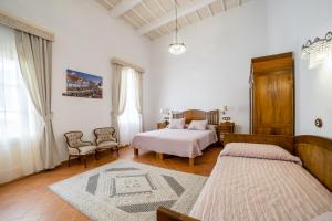 休达德亚Seranova Luxury Hotel - Adults Only的白色卧室配有两张床和一张沙发
