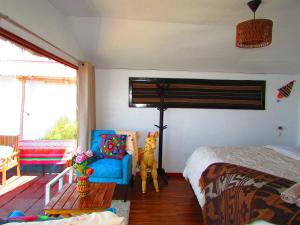 普诺Titicaca tikary's lodge的一间卧室配有一张床和一张蓝色椅子