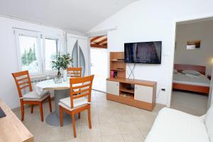 波尔托罗Sea View Apartments Portoroz ZM的客厅配有桌椅和电视。
