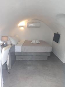 FoinikiáAQUA SERENITY LUXURY SUITES SANTORINI的一间小卧室,配有一张床和一张书桌