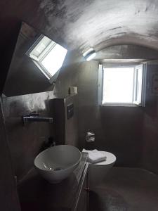 FoinikiáAQUA SERENITY LUXURY SUITES SANTORINI的一间带水槽和卫生间的浴室以及窗户。