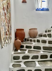 帕罗奇亚Nostos Studios的两瓶花被坐在瓷砖地板上