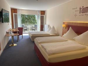 巴特申博恩哈夫纳酒店的酒店客房设有两张床和一张桌子。