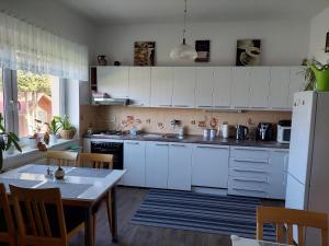 特罗亚诺维采Ubytování u Solárky的厨房配有白色橱柜、桌子和冰箱。