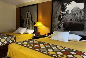 凯蒂西休斯顿凯蒂速8汽车旅馆的酒店客房设有两张床,墙上挂有绘画作品