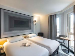 南希ibis Nancy Centre Stanislas的酒店客房设有两张床和一台平面电视。
