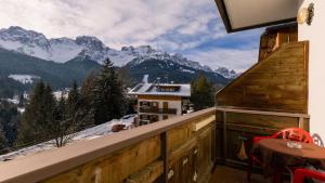 上科梅利科HOTEL DOLOMITI di De Martin D Oscar的阳台享有雪覆盖的山脉美景。