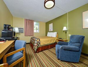 迈诺特迈诺特速8酒店的酒店客房,配有一张床和两把椅子