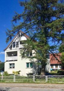 米罗strandnahe FeWo mit Floß ( 24 h) und eigenem Kanu的前面有棵树的白色建筑
